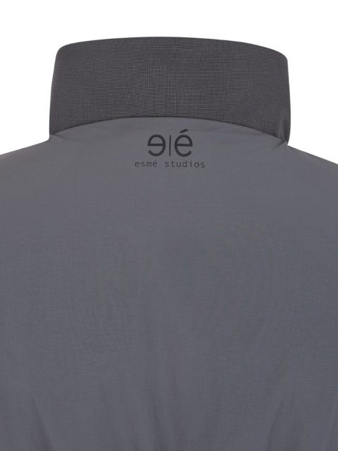 Nahaufnahme von Dunkelgrauer Jacke von hinten, die am Nacken mit dem Logo 
