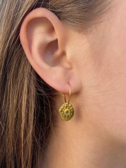 Hangemachter Gold Ohrring, die an einem dünnen Reifen angehängt ist. Der Anhang ist eine goldige Plakette, mit einem kleinen grünen Stein in der Mitte.